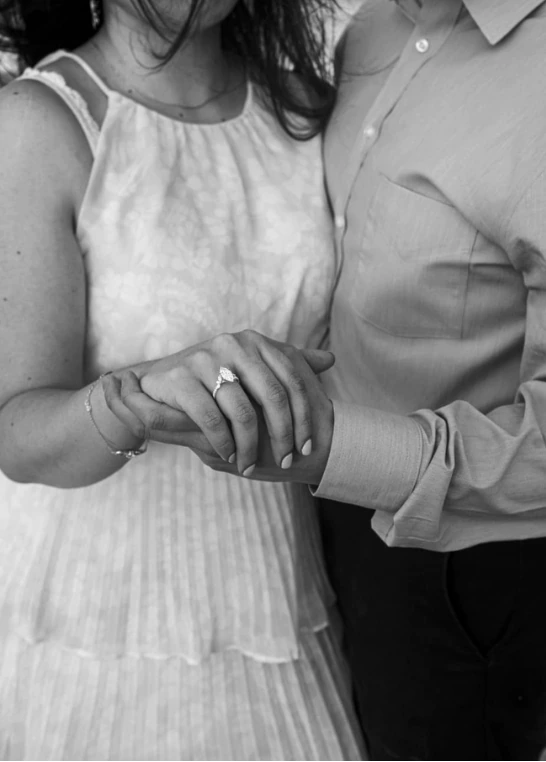 Close-up of Sofia's hand in Carlos's, showing her engagement ring.